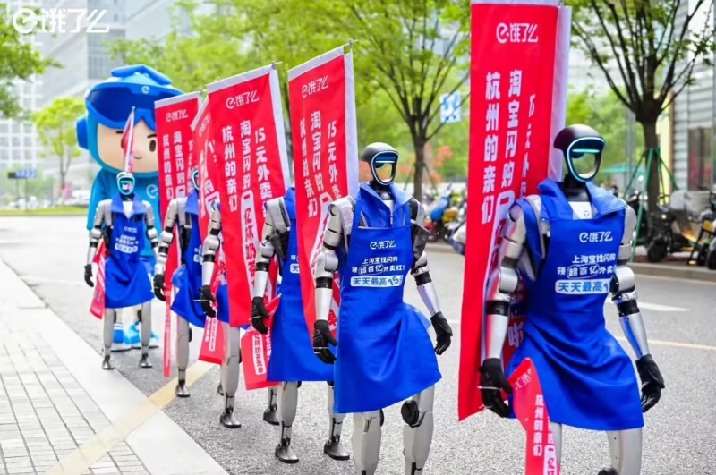 饿了么租宇树人形机器人在街头宣传“闪购”，即时零售大战各出奇招(图1)